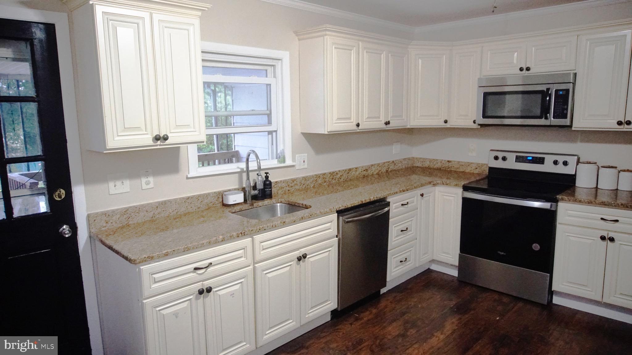 567 South Fairview Street Riverside, NJ 08075 - Photo 7 of 29 a kitchen with white cabinets and black appliances