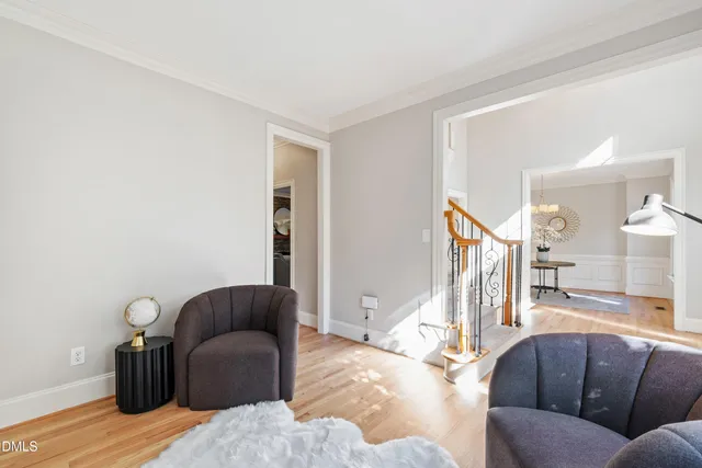a dining room with wooden floor a chandelier a wooden table and chairs