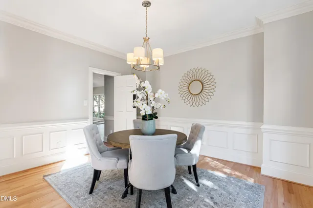 a dining room with furniture a chandelier and wooden floor