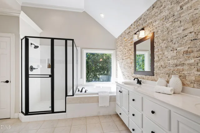 a bathroom with a double vanity sink a mirror and a bathtub