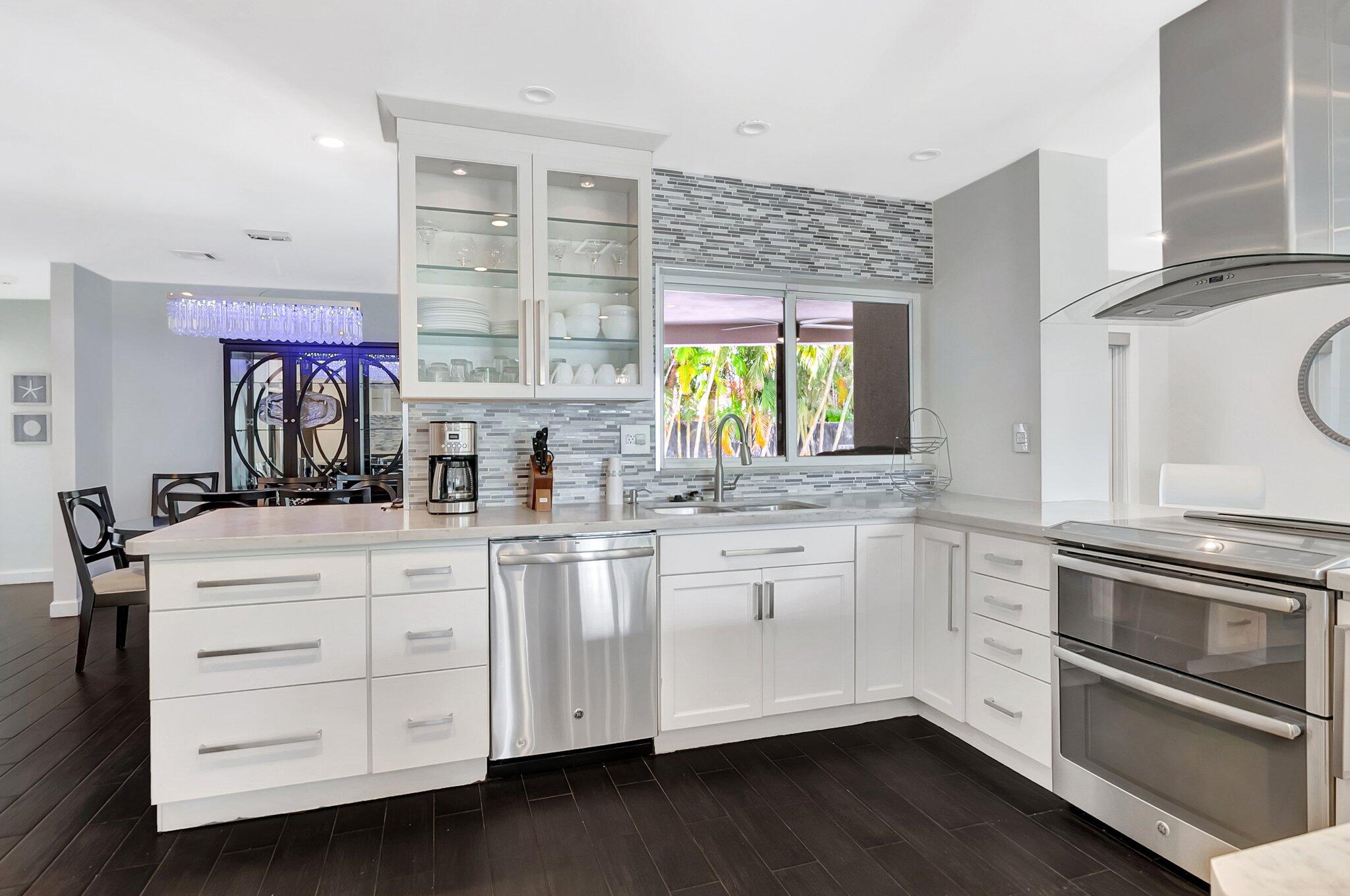 855 Berkley Street Boca Raton, FL 33487 - Photo 12 of 34 a kitchen with stainless steel appliances white cabinets and a wooden floor