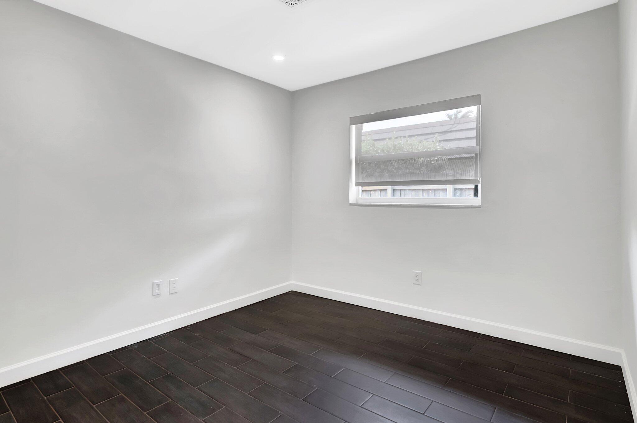 855 Berkley Street Boca Raton, FL 33487 - Photo 26 of 34 a view of an empty room with wooden floor and a window