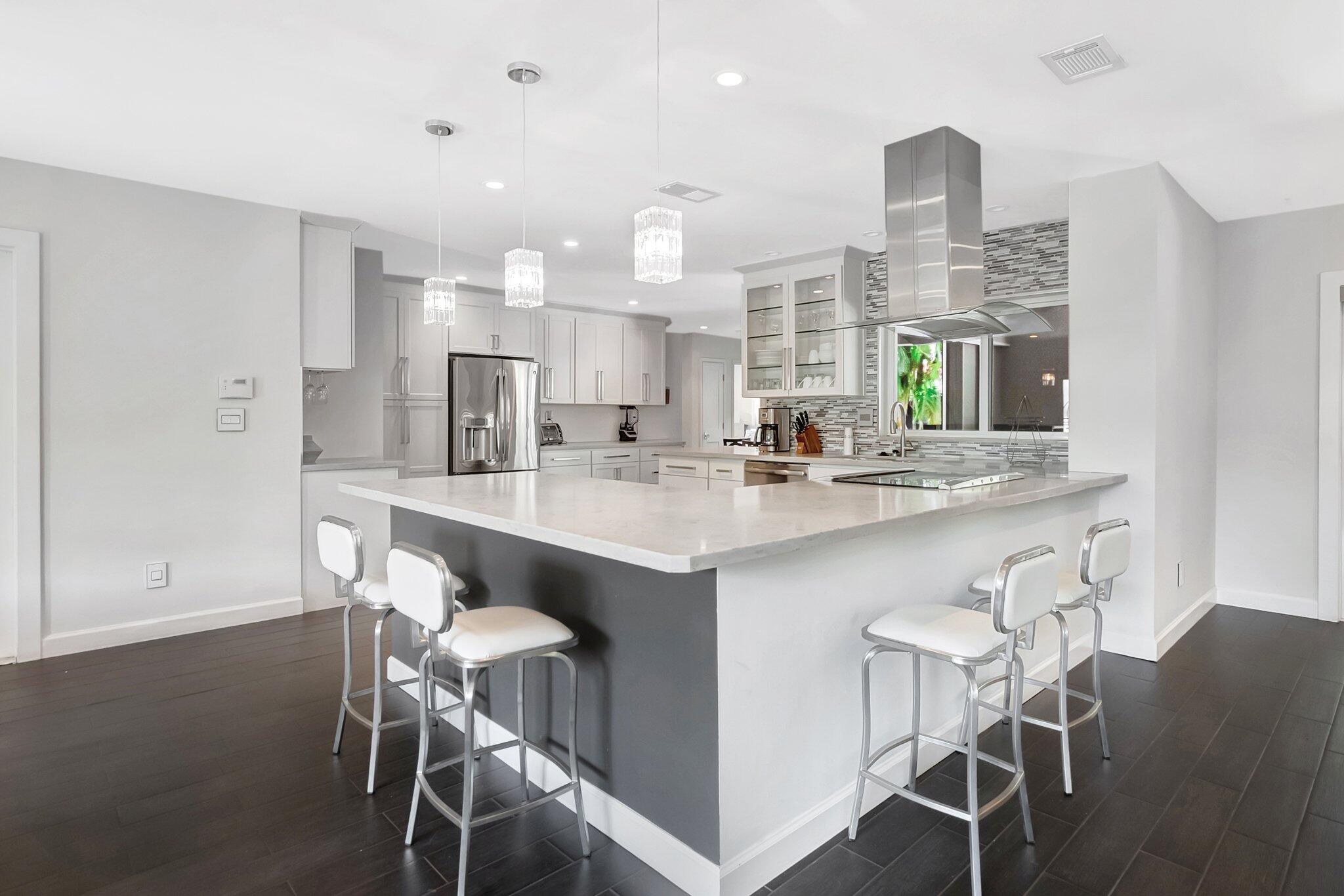 855 Berkley Street Boca Raton, FL 33487 - Photo 10 of 34 a kitchen with kitchen island granite countertop a sink and chairs