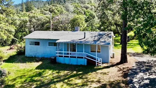 a view of a house with a yard balcony and a tree