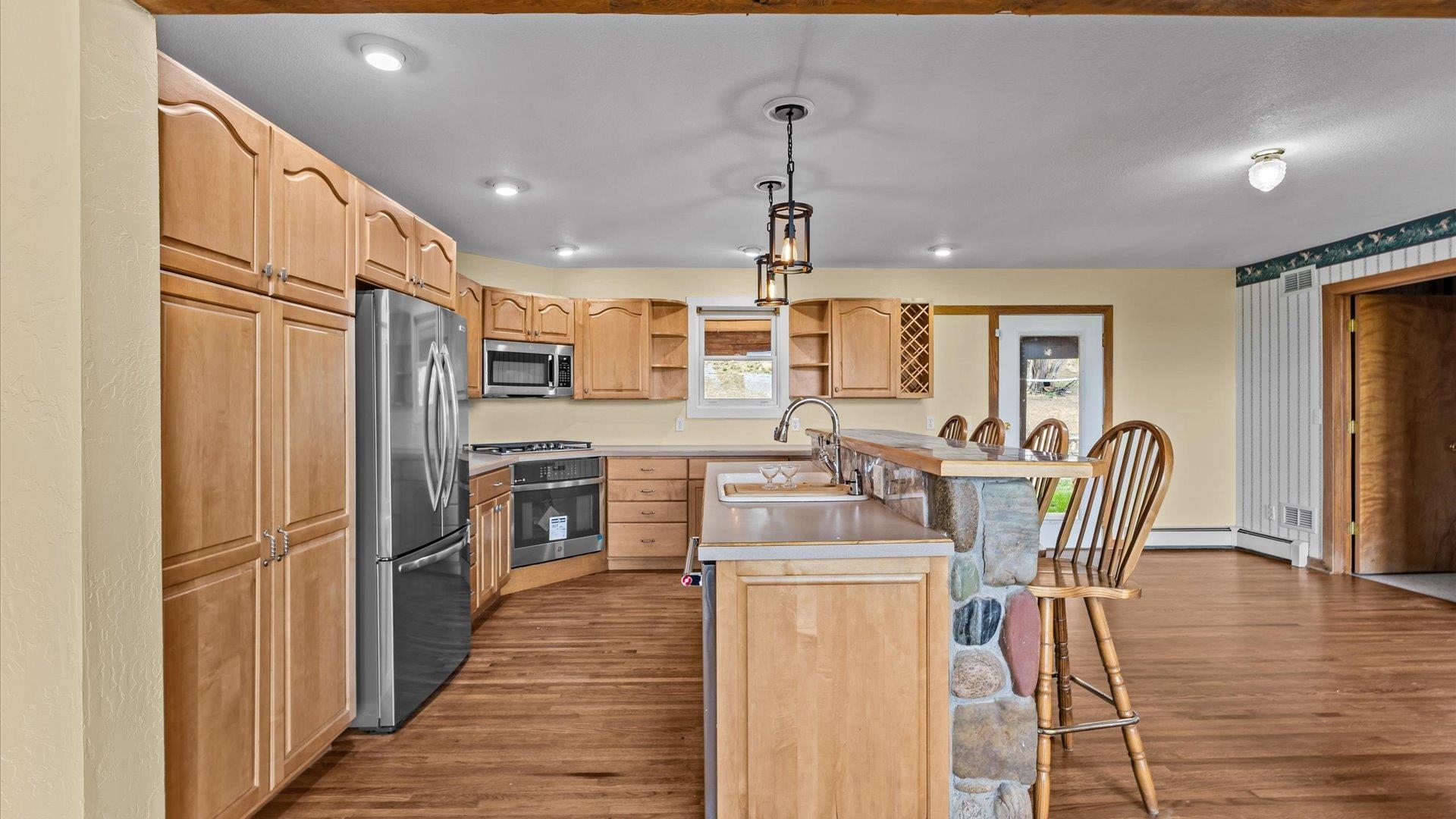 2737 Six Lazy K Road Silt, CO 81652 - Photo 17 of 42 a kitchen with stainless steel appliances kitchen island granite countertop a refrigerator a stove top oven a sink dishwasher a dining table and chairs with wooden floor