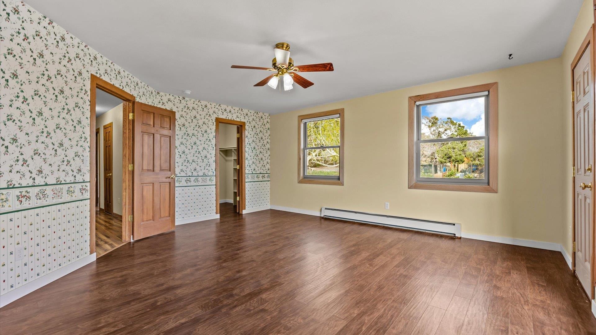 2737 Six Lazy K Road Silt, CO 81652 - Photo 27 of 42 an empty room with wooden floor chandelier fan and windows