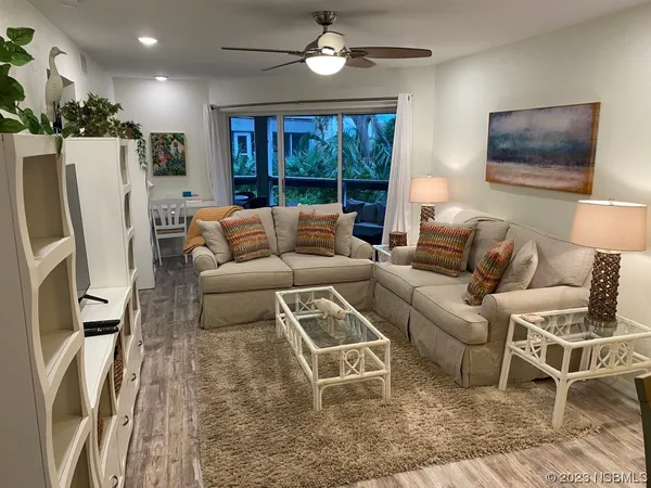 a living room with furniture a large window and a flat screen tv