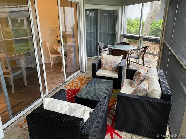 a balcony with furniture and a potted plant