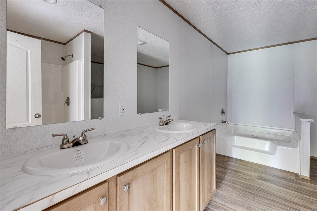 474 Bryant Road Pelzer, SC 29669 - Photo 23 of 42 Double vanity with ample counter space alongside a soaking tub and shower area.