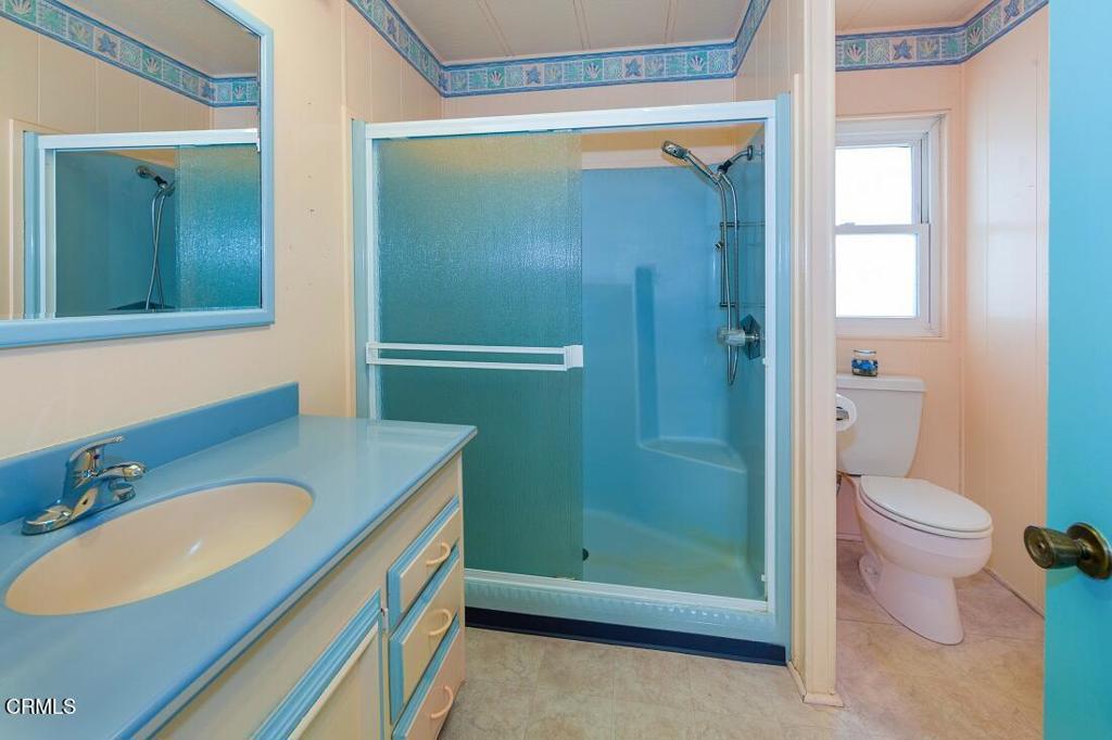 5540 West 5th Street, Unit 127 Oxnard, CA 93035 - Photo 12 of 17 a bathroom with a granite countertop sink toilet and shower