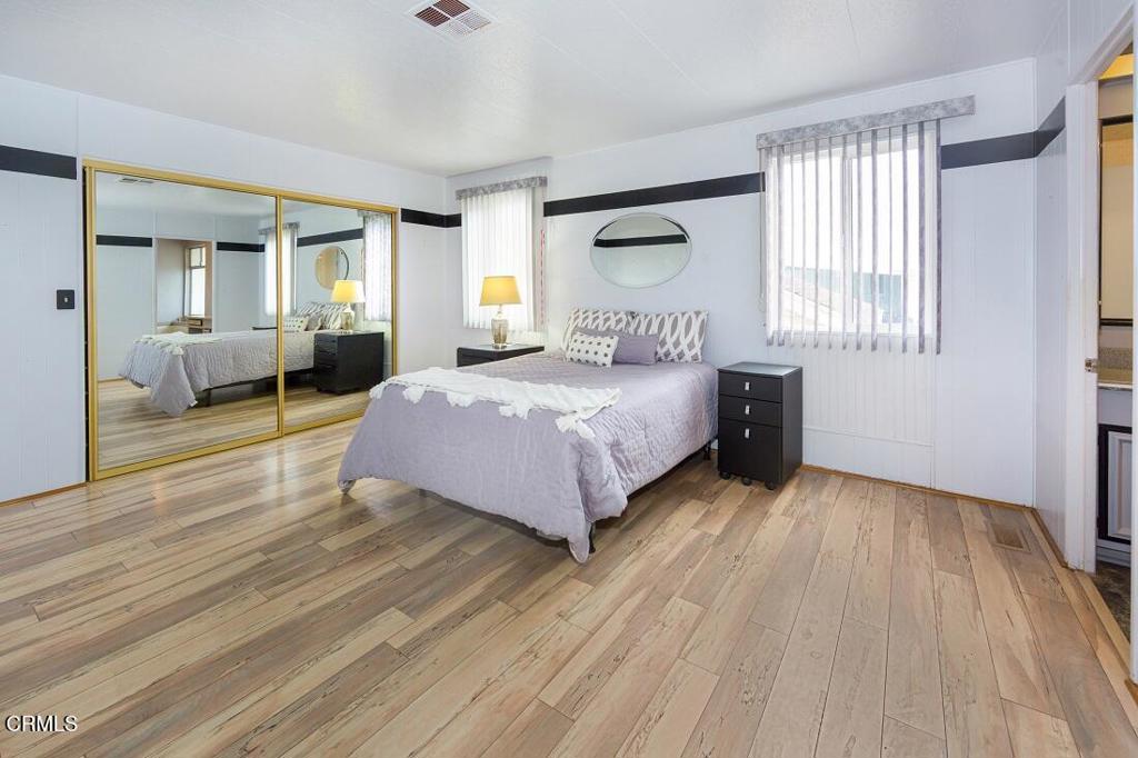 5540 West 5th Street, Unit 127 Oxnard, CA 93035 - Photo 14 of 17 a bedroom with a bed and wooden floor