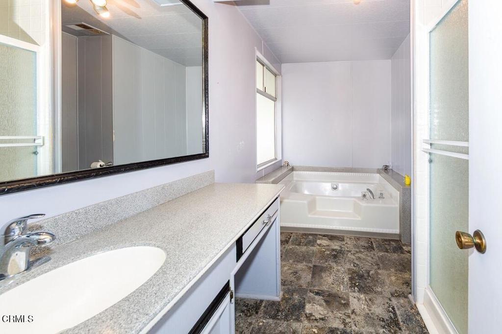 5540 West 5th Street, Unit 127 Oxnard, CA 93035 - Photo 15 of 17 a bathroom with a granite countertop sink and a mirror