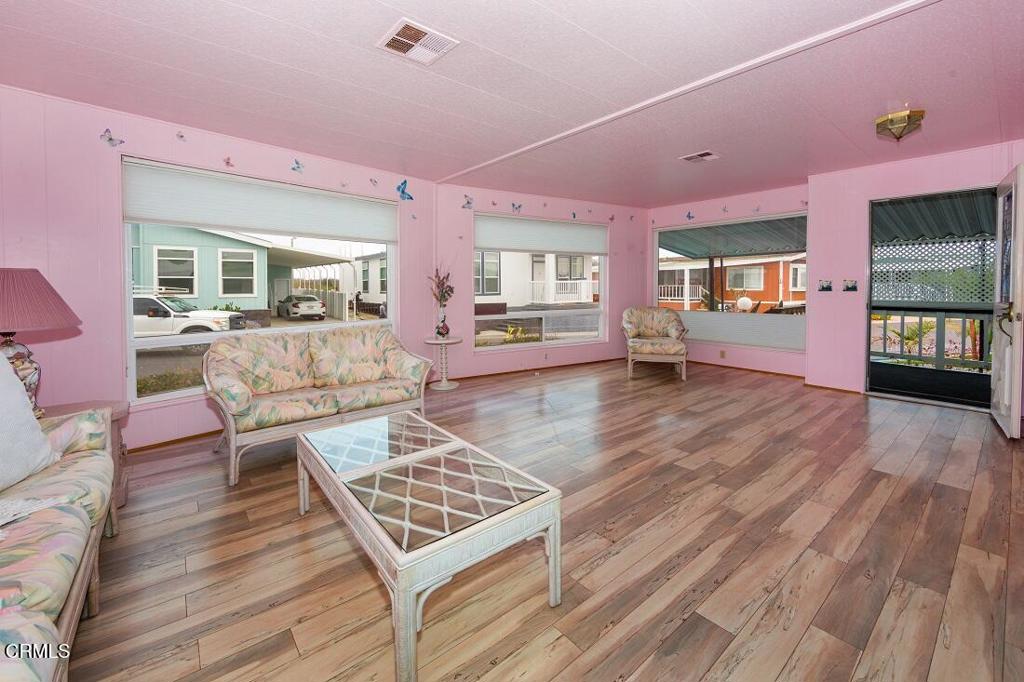 5540 West 5th Street, Unit 127 Oxnard, CA 93035 - Photo 4 of 17 a living room with furniture and wooden floor