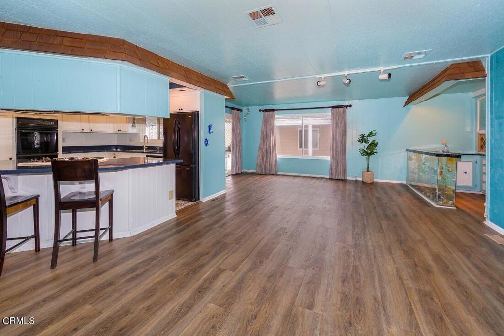 5540 West 5th Street, Unit 127 Oxnard, CA 93035 - Photo 10 of 17 a view of a kitchen with furniture and wooden floor
