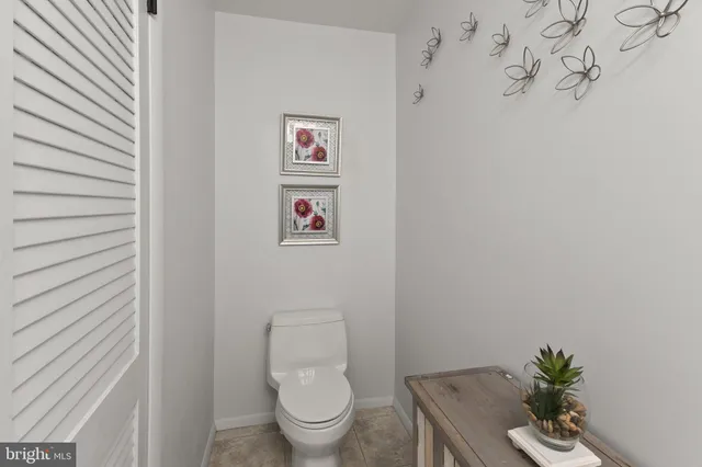 a white toilet sitting next to a white wall