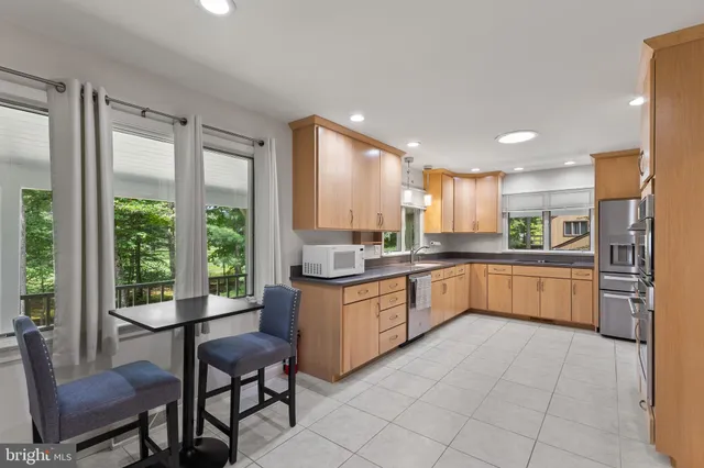 a large kitchen with a large window and white stainless steel appliances