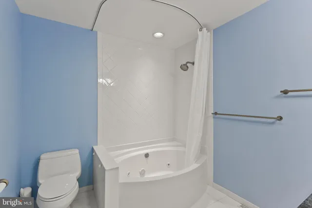 a white toilet sitting next to a bath tub