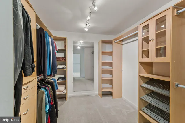 a view of walk in closet with clothes and shoes