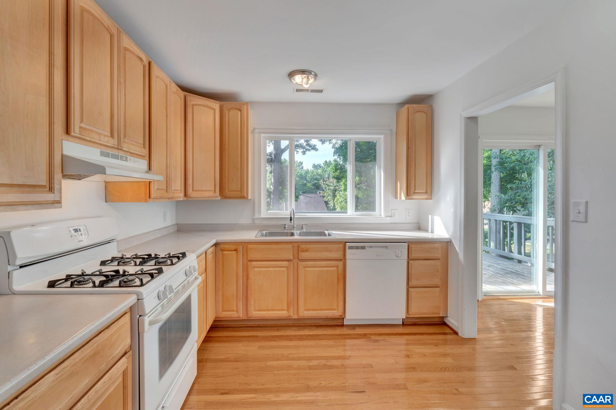 392 Minor Ridge Road Charlottesville, VA 22901 - Photo 15 of 47 a kitchen with granite countertop a stove a sink and white cabinets with wooden floor