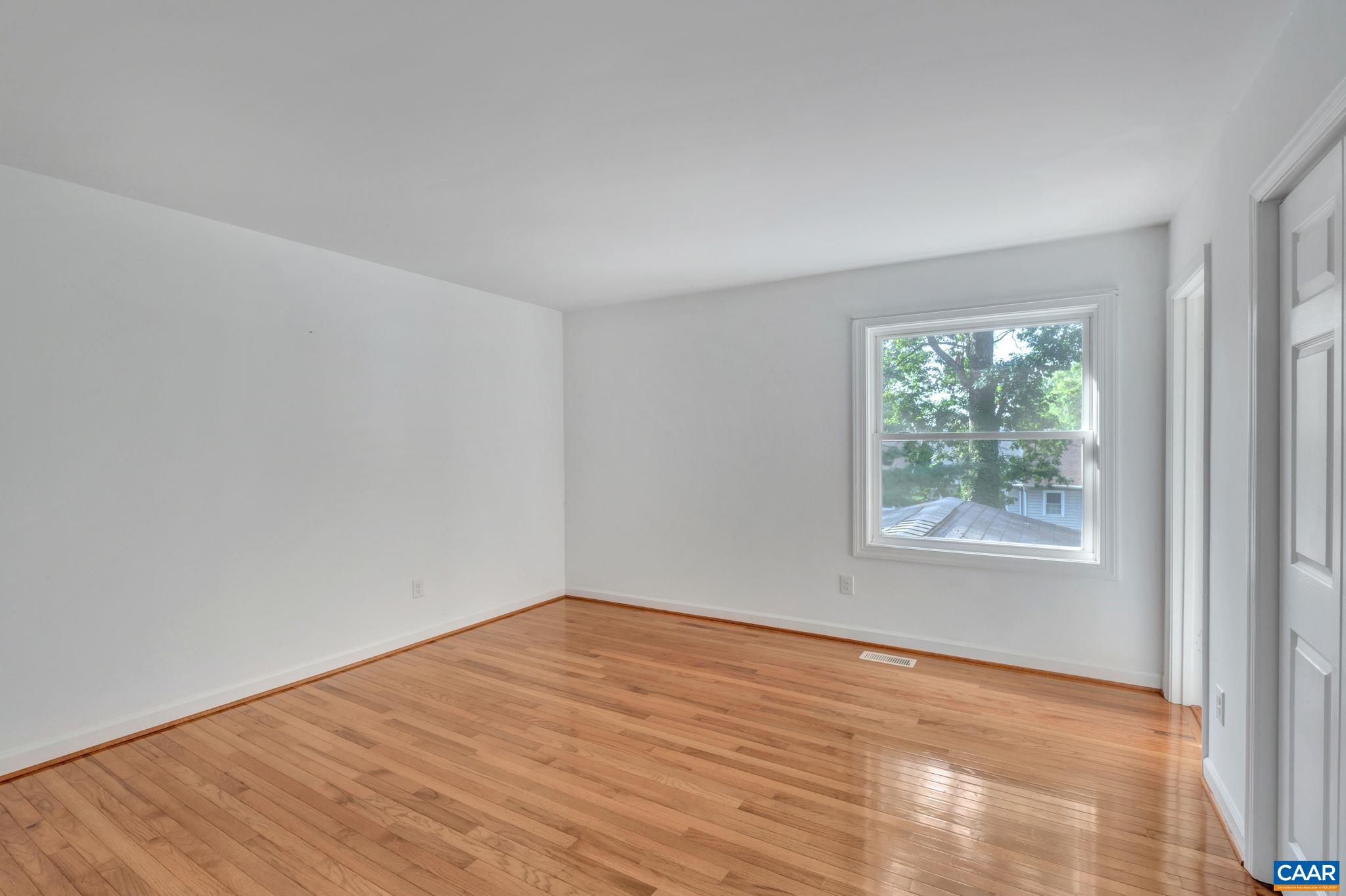 392 Minor Ridge Road Charlottesville, VA 22901 - Photo 22 of 47 an empty room with wooden floor and windows