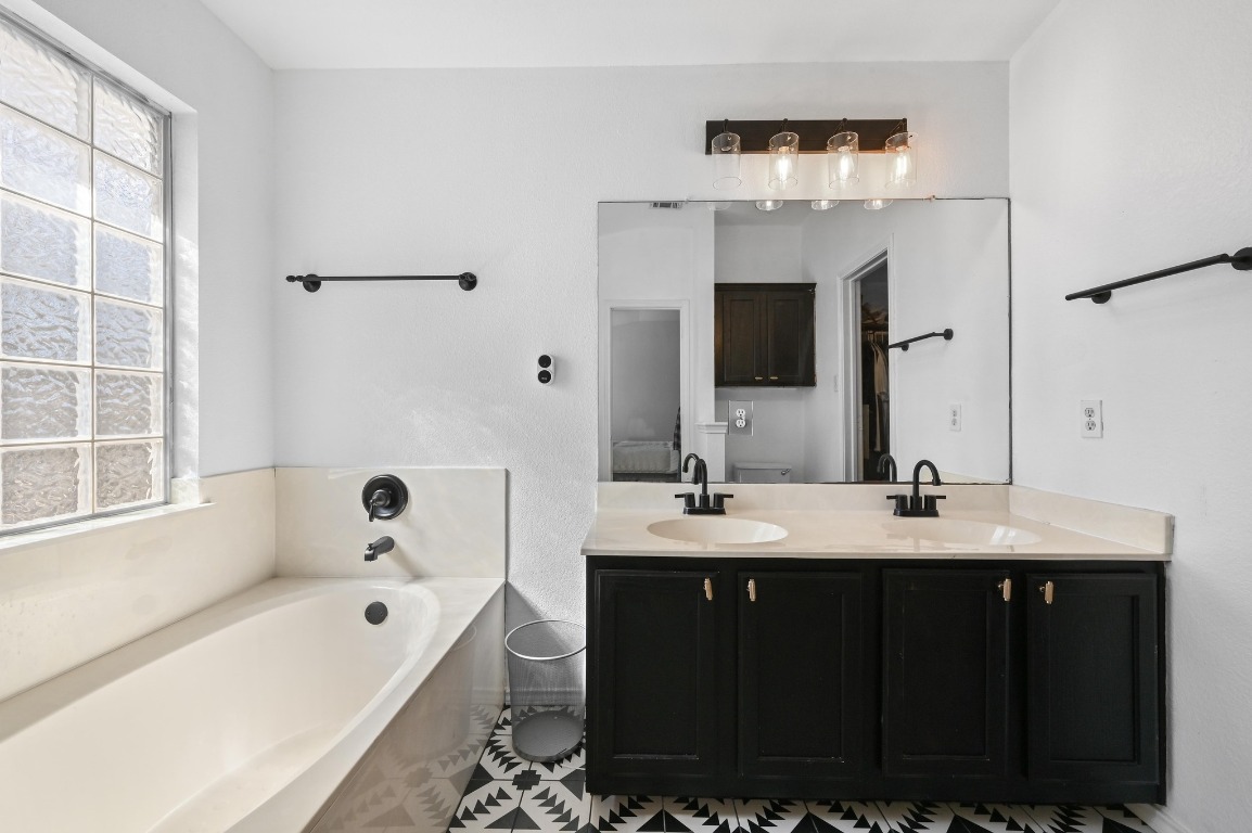 1451 Roxanne's Run Pflugerville, TX 78660 - Photo 11 of 17 a bathroom with a tub sink double vanity granite and shower