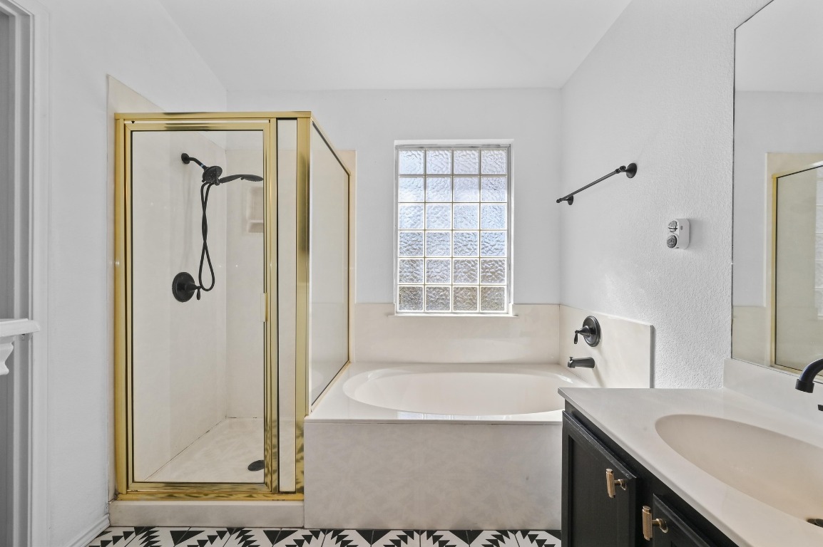 1451 Roxanne's Run Pflugerville, TX 78660 - Photo 12 of 17 a bathroom with a granite countertop sink a mirror and a bathtub