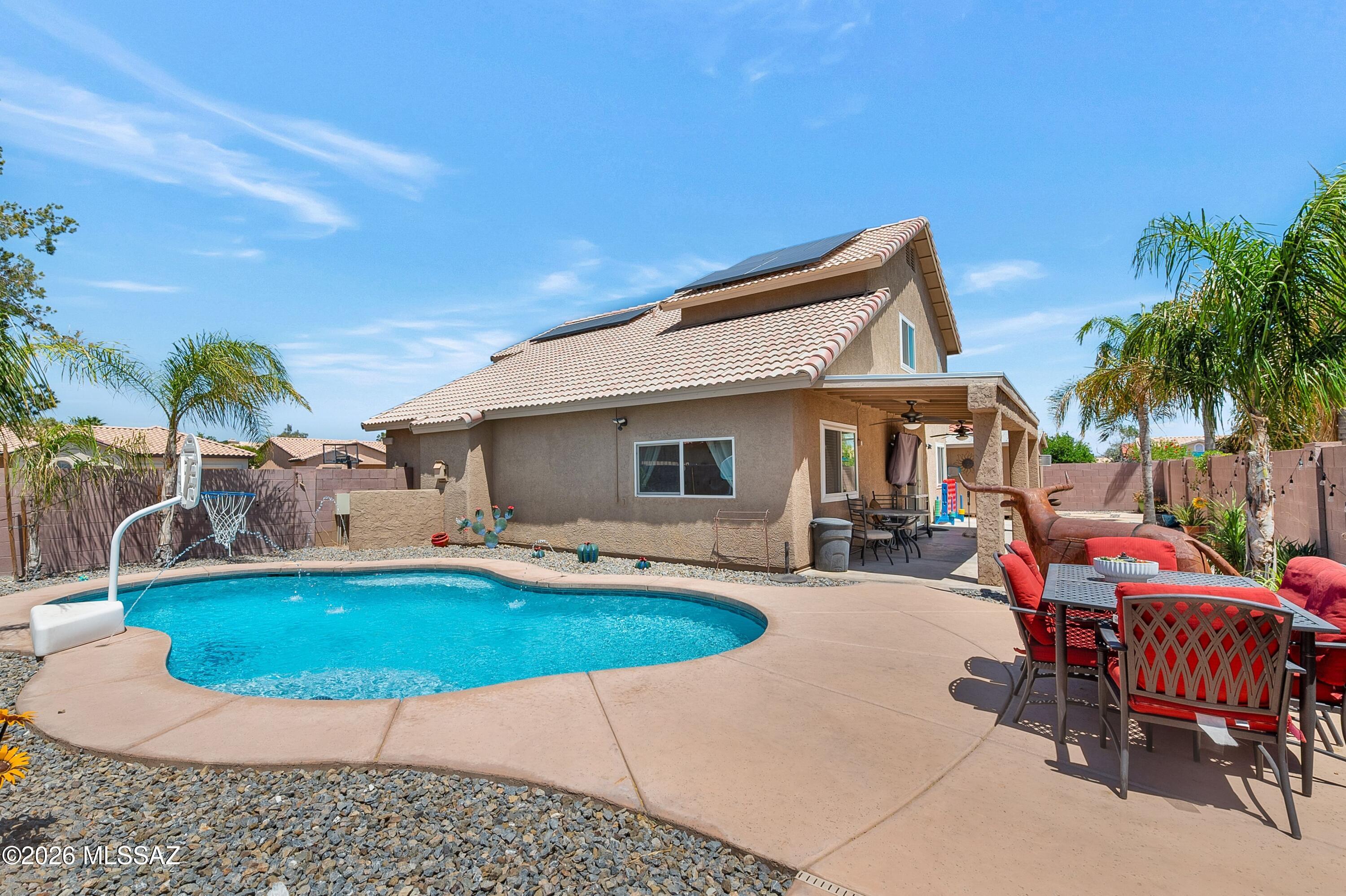 7159 West Maple Ridge Drive Tucson, AZ 85743 - Photo 27 of 42 a patio with a table and chairs and potted plants
