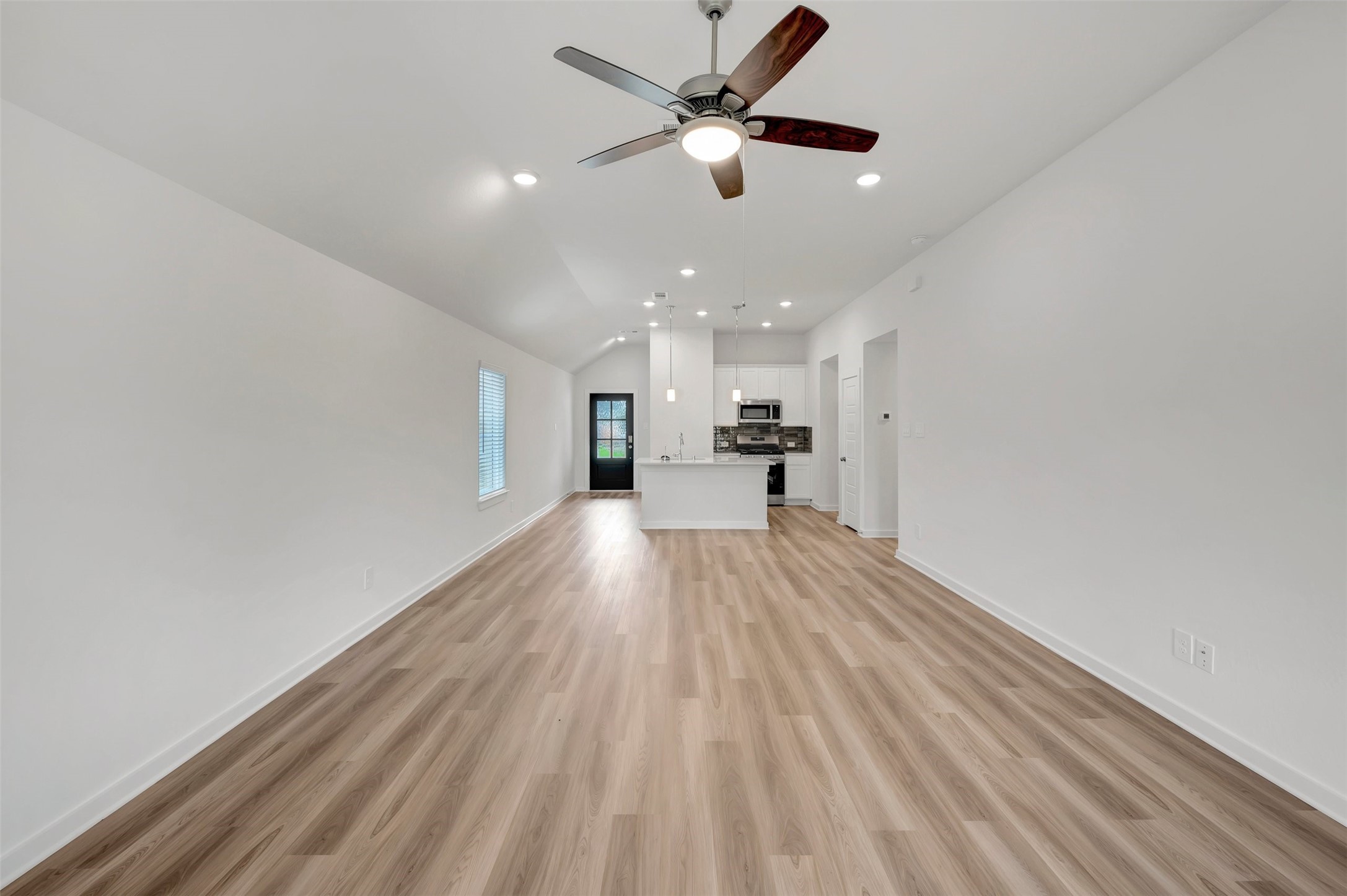 543 Flower Reed Court Magnolia, TX 77354 - Photo 32 of 46 a view of a big room with wooden floor a ceiling fan and windows