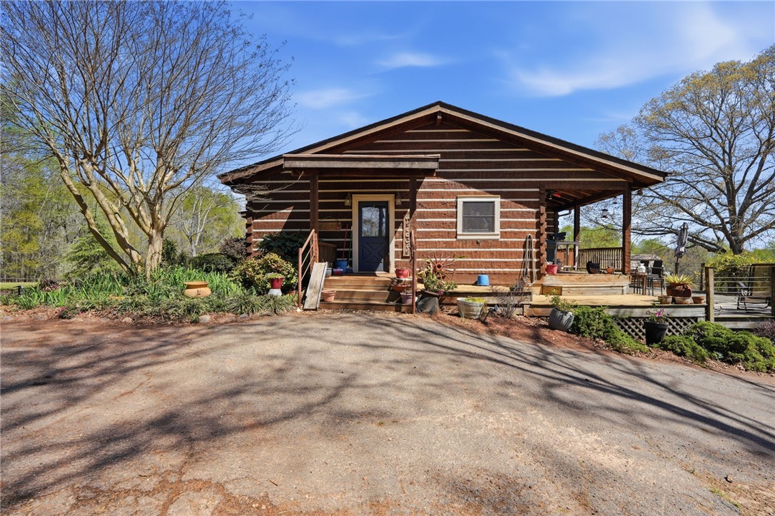 This charming cabin home features a welcoming front porch and an expansive deck, perfect for outdoor living.