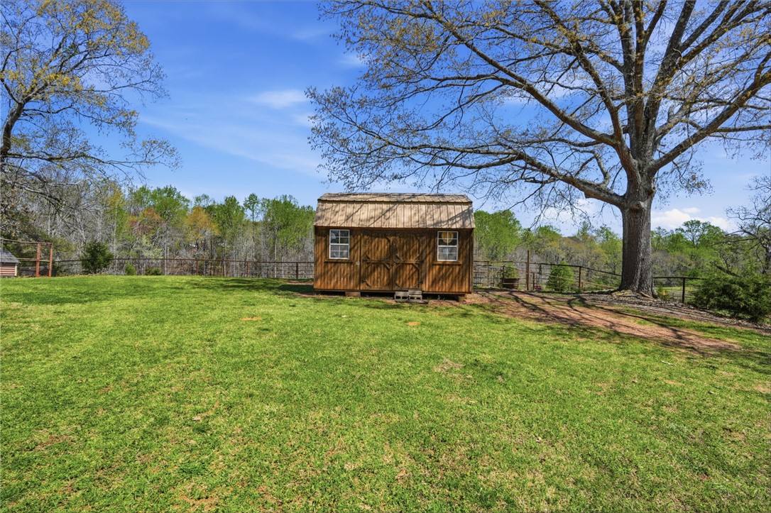 608 Five Forks Road Anderson, SC 29621 - Photo 7 of 43 This expansive yard features a charming wooden shed, offering both utility and a rustic aesthetic.