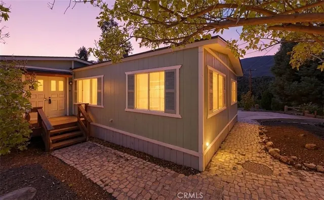 a view of house with backyard and outdoor seating