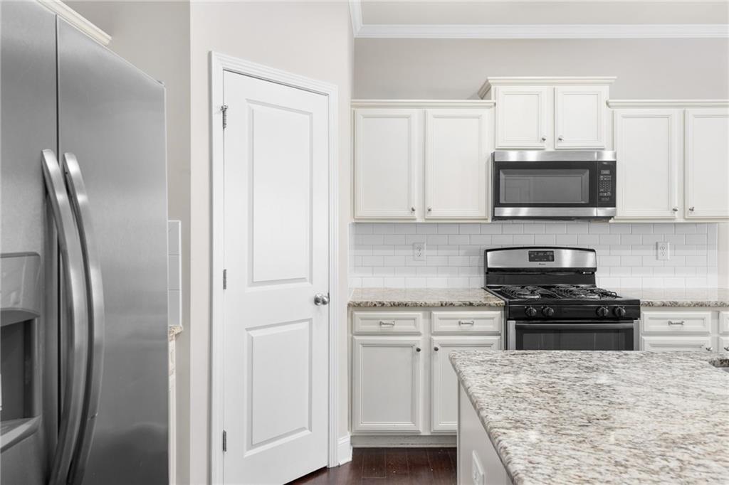 1925 Wheylon Drive Lawrenceville, GA 30044 - Photo 13 of 55 a kitchen with white cabinets and stainless steel appliances