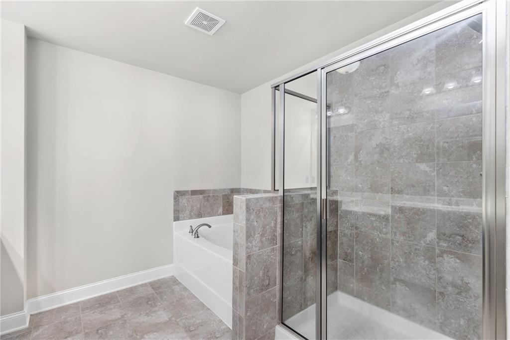 1925 Wheylon Drive Lawrenceville, GA 30044 - Photo 38 of 55 a bathroom with a shower and a bath tub