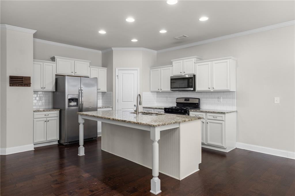 1925 Wheylon Drive Lawrenceville, GA 30044 - Photo 8 of 55 a kitchen with a sink a stove a refrigerator and white cabinets