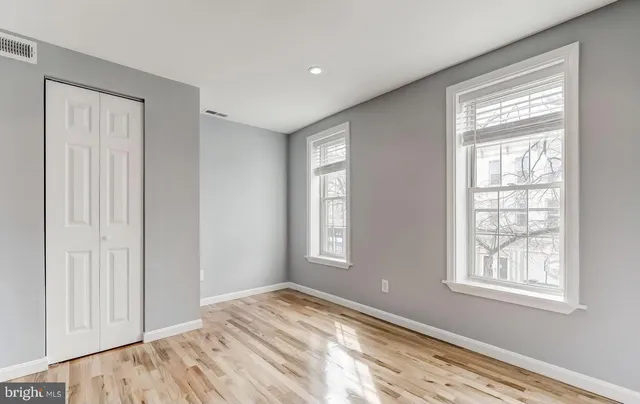 a view of empty room with wooden floor