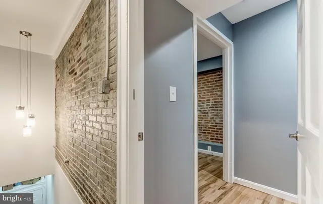 a view of hallway with window and wooden floor