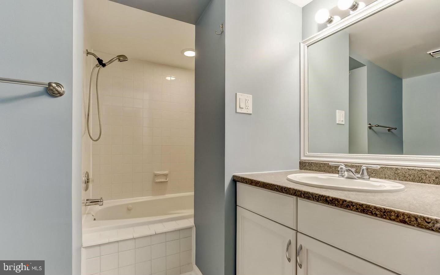 1049 South Charles Street Baltimore, MD 21230 - Photo 30 of 33 a bathroom with a granite countertop sink mirror and a bathtub