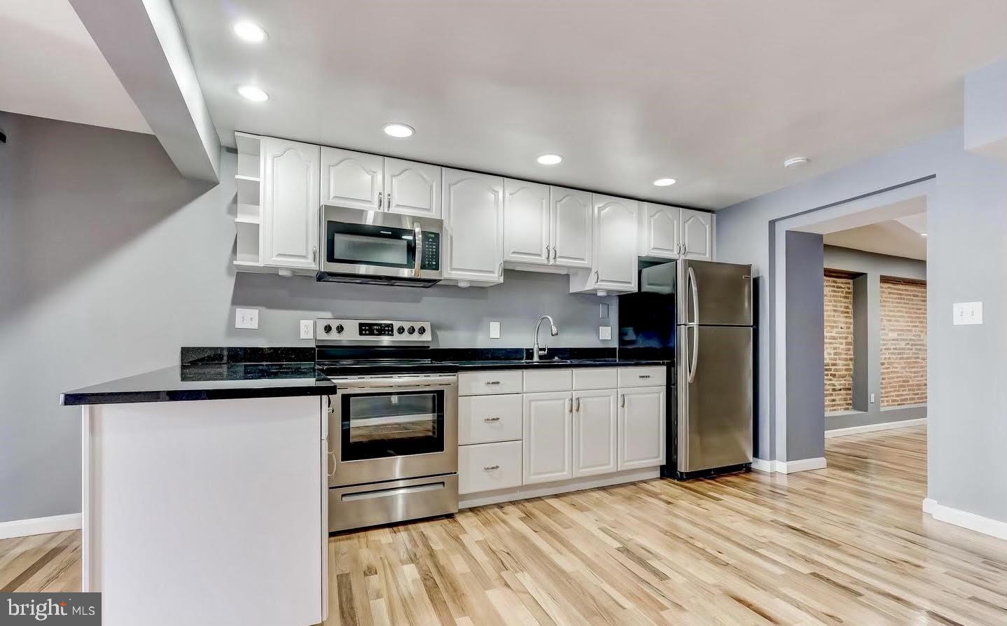 1049 South Charles Street Baltimore, MD 21230 - Photo 6 of 33 a large kitchen with stainless steel appliances granite countertop a stove a sink and a refrigerator