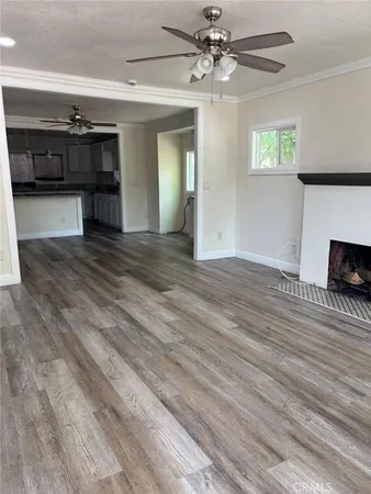 a view of a livingroom with wooden floor and a ceiling fan