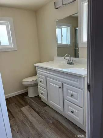 a bathroom with a granite countertop toilet sink and mirror