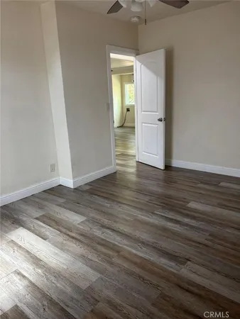 an empty room with wooden floor and entrance