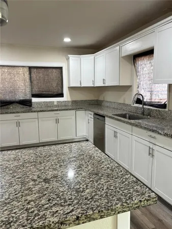 a kitchen with granite countertop a sink and cabinets