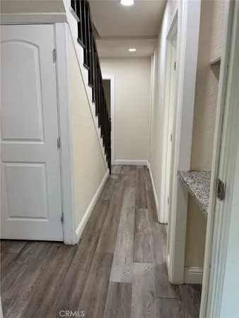 a view of a hallway with wooden floor and staircase