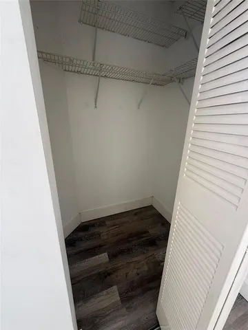 a view of a room with wooden floor and white walls