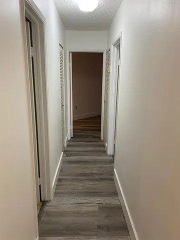 a view of a hallway with wooden floor and entryway
