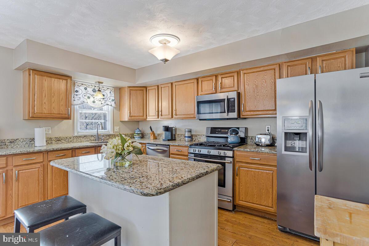 9012 Phyllis Drive Clinton, MD 20735 - Photo 8 of 33 a kitchen with granite countertop stainless steel appliances a sink stove refrigerator and a window