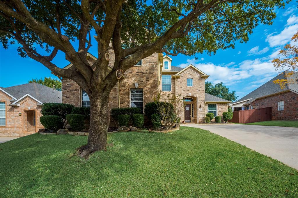 a front view of a house with a yard and trees