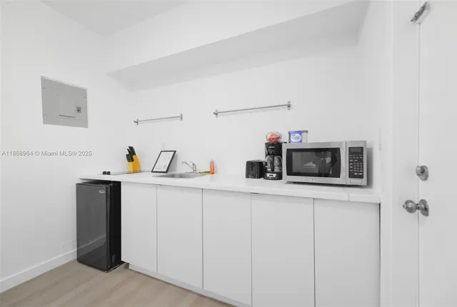 a kitchen with stainless steel appliances cabinets and wooden floor