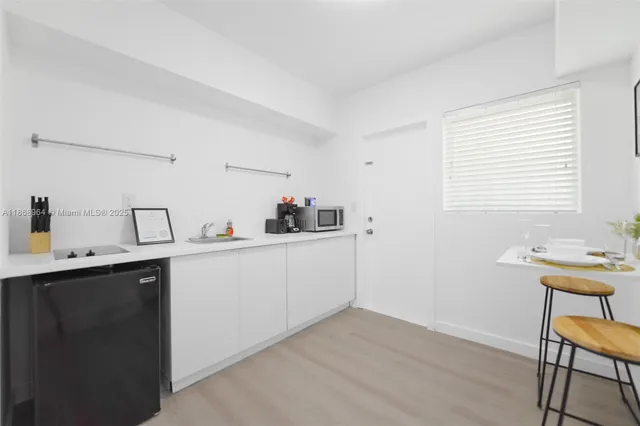 a kitchen with a sink cabinets and wooden floor