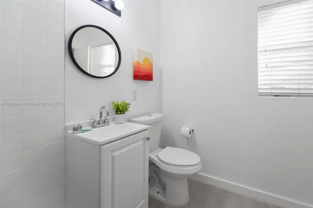 a bathroom with a toilet a sink and mirror
